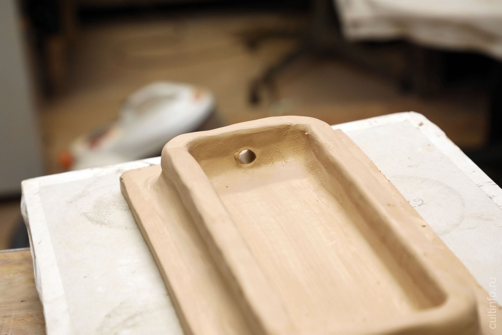 Отверстие для гвоздя, с помощью которого изразец крпится к печи